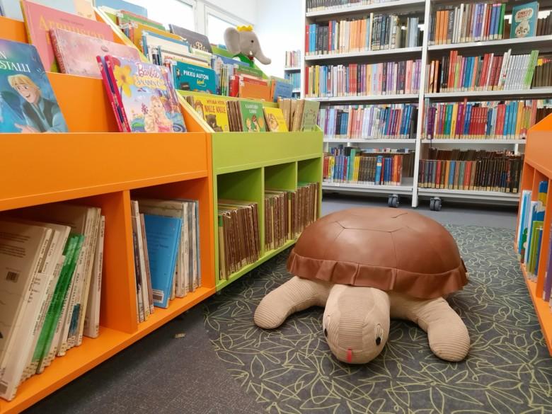 Pehmolelu kilpikonna kirjaston lastenosastolla