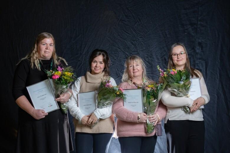 Annika Seppälä, Anu Pulkkinen, Katri Vähämäki ja Katariina Pitkänen hymyilevät kuvassa kädessään onnittelukukat ja kunniakirjat.
