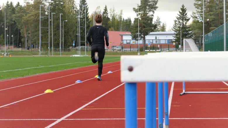 Juoksija keskuskusurheilukentän juoksuradalla.